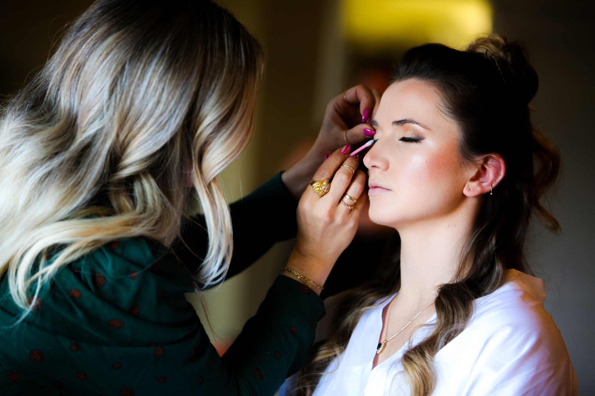 A bride has her makeup done before her wedding day at the grove park inn. 