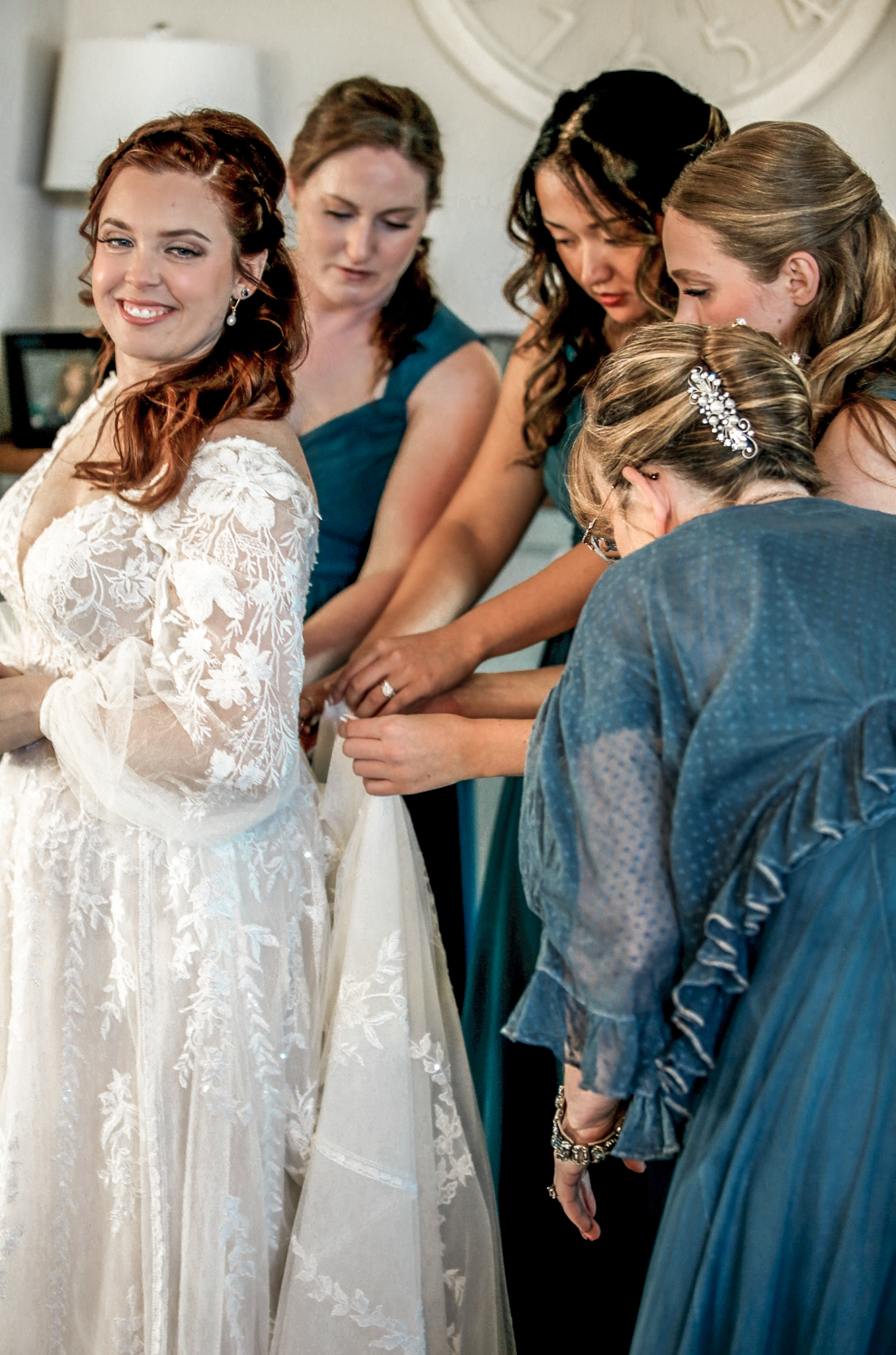 Bridesmaids help a bride get into her wedding dress at a beach wedding in North Carolina. 