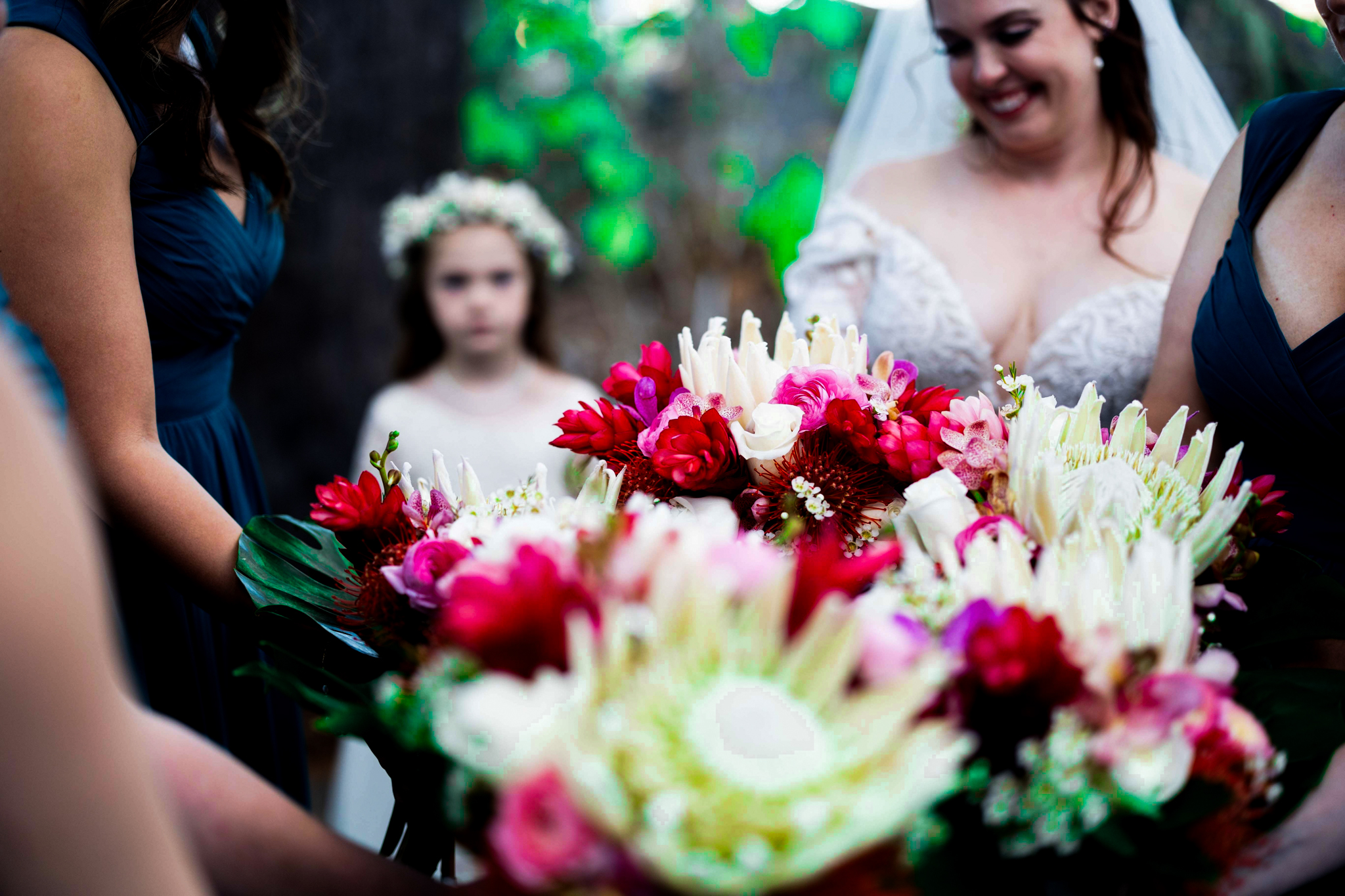 A flower girl watches a wedding party before walking dow the aisle. 